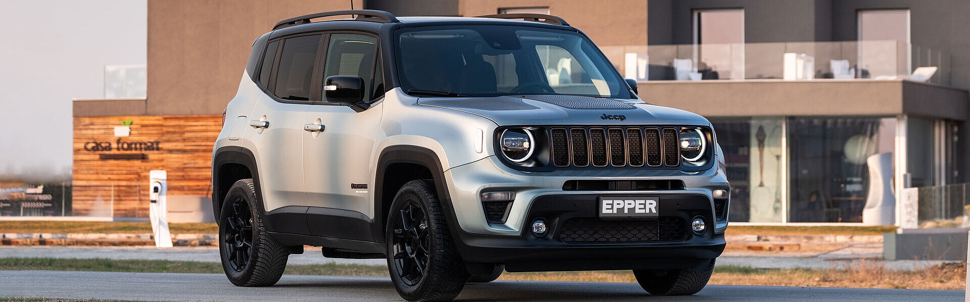Der neue Jeep Renegade e-hybrid vor einem grossen Haus