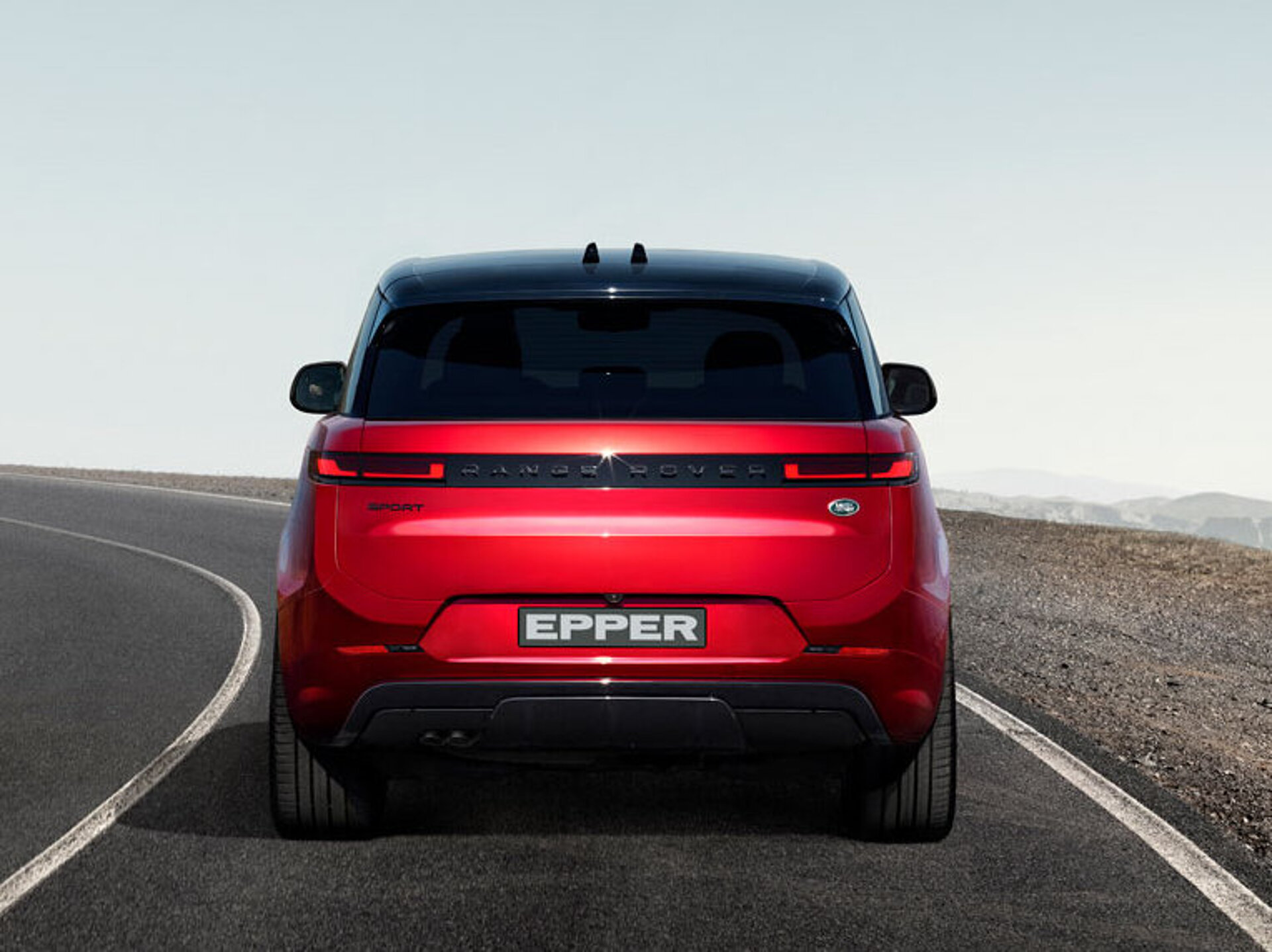 Der neue Range Rover Sport auf einer Strasse von hinten Der neue Range Rover Sport auf einer Strasse von hinten