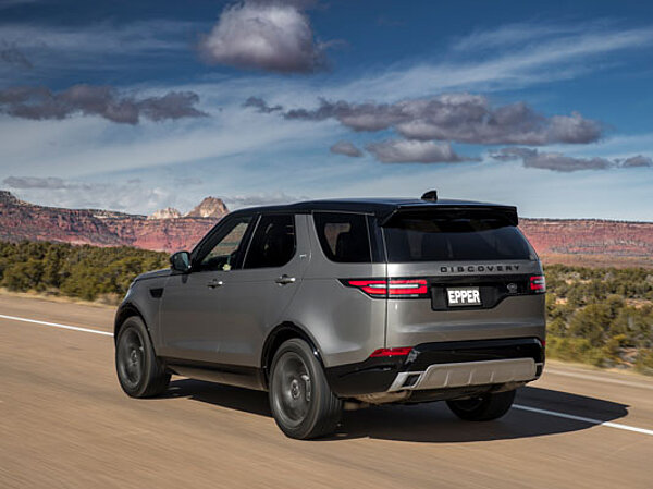 Der neue Land Rover discovery auf einer Landstrasse in der Heckansicht