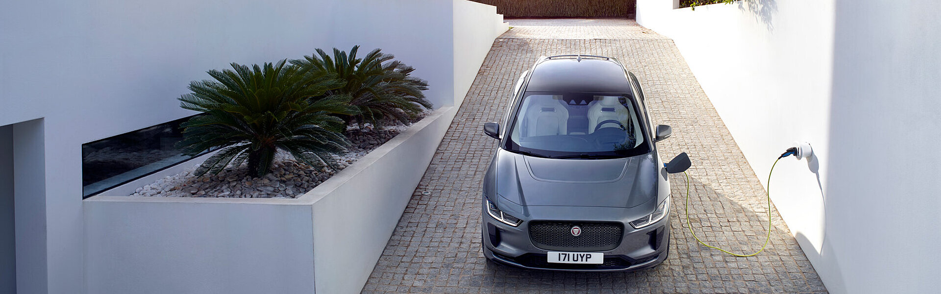 Ein Jaguar I-Pace steht vor einem Haus und wird geladen